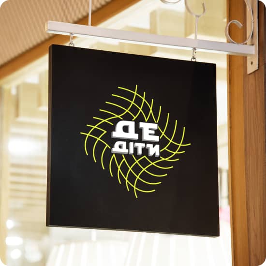 Логотип ДеДіти жовто-білого кольору на квадратній вивісці фасаду чорного кольору