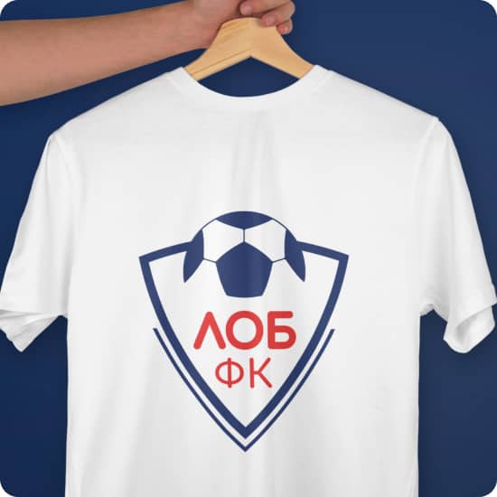 Витягнута рука тримає вішак з білою футболкою на якій нанесено великий логотип футбольної команди ФК ЛОБ в червоному та синьому кольорах